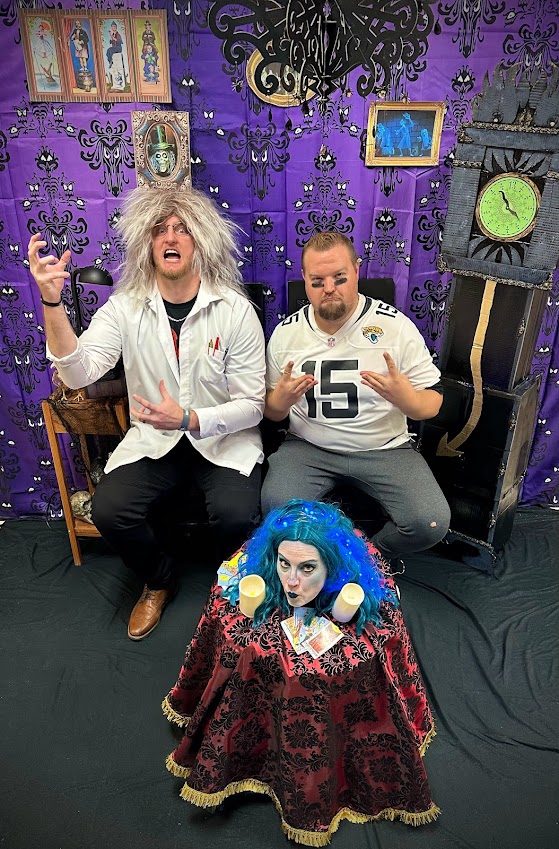 Madame Leota (Mrs. Goulding), the crazy scientist (Mr. Lewis), and Mr. Football (Mr. Bowles) posing in front of the Haunted Mansion backdrop