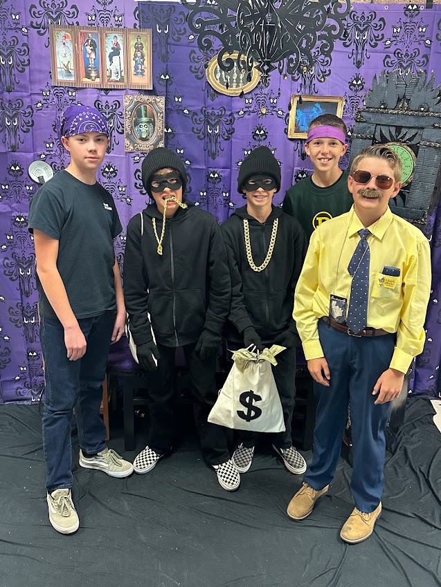 One student dressed as a Liberty Mutual sales rep, two dressed as bank robbers, and a two with purple bandanas on Halloween.
