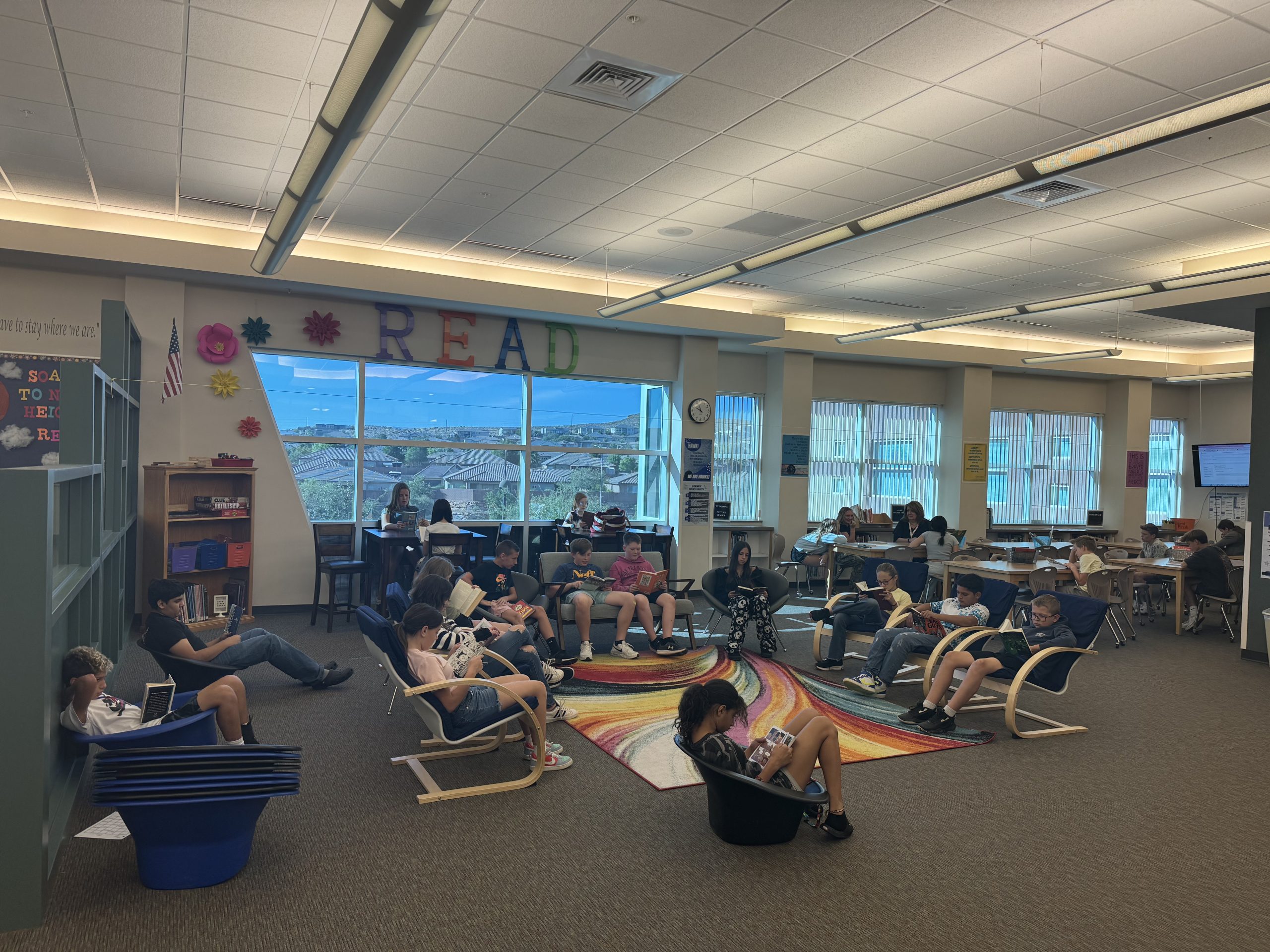 Mrs. Nisson's class spreads out in the library's reading lounge and reads quietly.