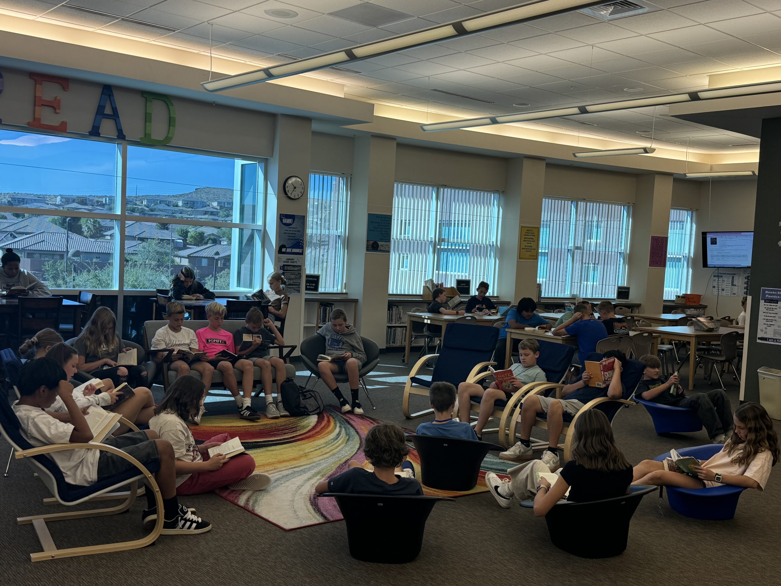 Ms. Nisson's class sits comfortably in the library's reading lounge and enjoy a good book.