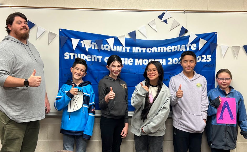 October Students of the Month for 6th Grade and Mr. Rarick standing in front of the decorated white board.